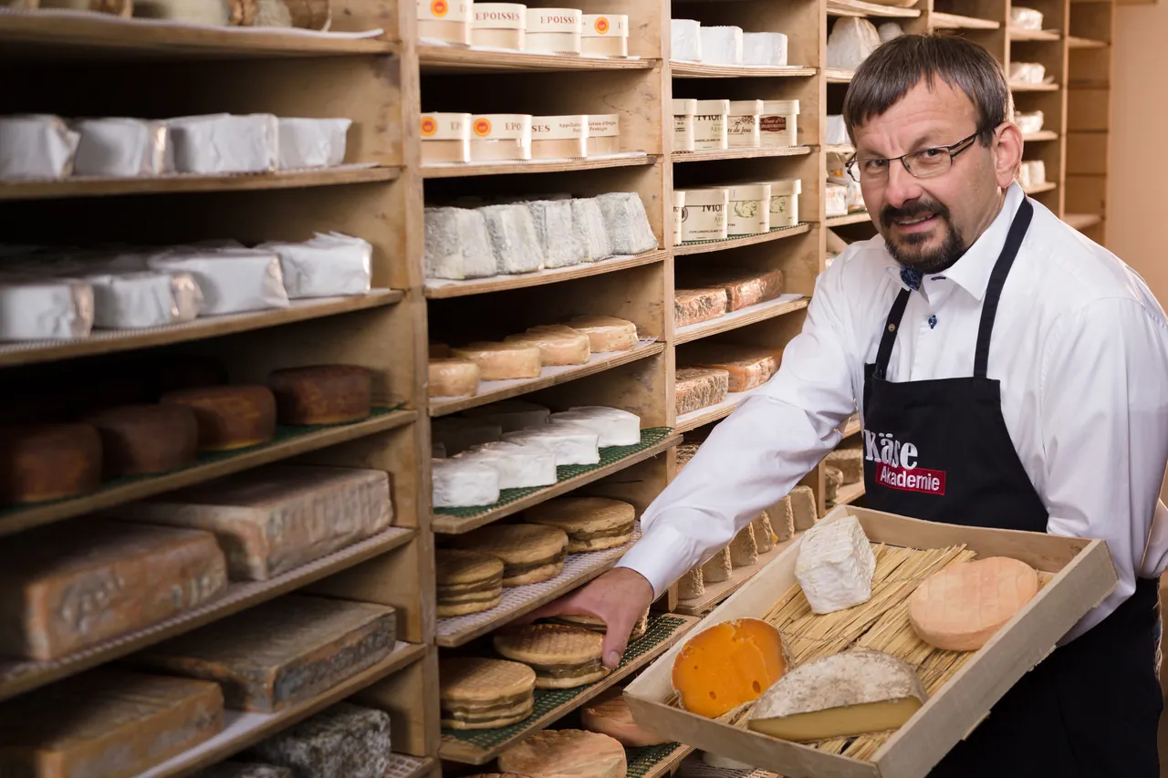 Wolfgang Hofmann mit einer Kiste ausgewählter Käse im Reiferaum in Bad Heilbrunn